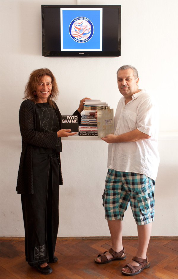 Marija Cvetnić Kopljar preuzima kniige koje daje Damir Tiljak u ime Fotokluba Zagreb